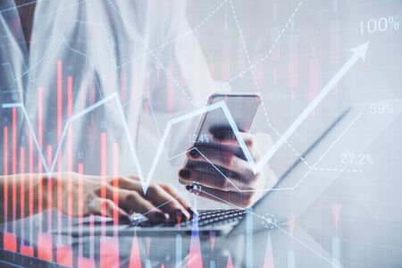 Double exposure of financial graph sketch hologram and woman holding and using a mobile device....