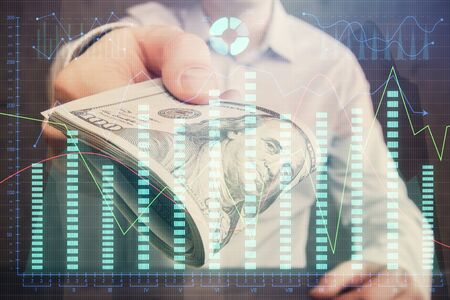 Multi exposure of financial graph drawing hologram and USA dollars bills and man hands. Analysis concept.の写真素材
