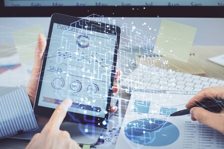Double exposure of mans hand holding and using a digital device and brain hologram drawing. Data concept.の写真素材