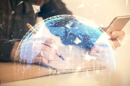 Double exposure of business theme sketch hologram and woman holding and using a mobile device.の写真素材