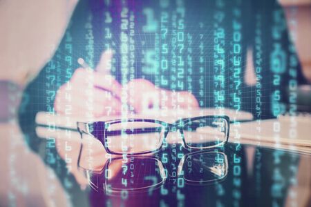 Double exposure of writing hands on background with data solution hologram on front. Technology...