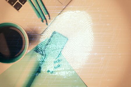 Finger print over computer on the desktop background. Top view. Double exposure. Concept of securitization.の写真素材