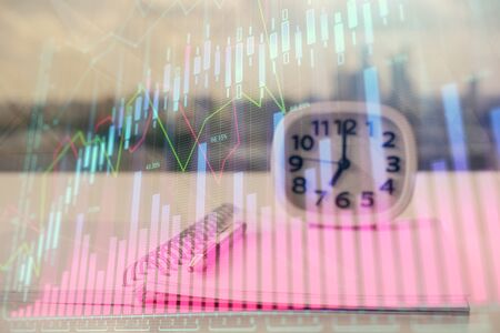 Double exposure of financial graph drawings and desk with open notebook background. Concept of forex marketの写真素材