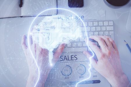 Double exposure of mans hands typing over computer keyboard and brain hologram drawing. Top view. Ai...