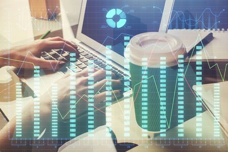 Double exposure of woman hands typing on computer and forex chart hologram drawing. Stock market...