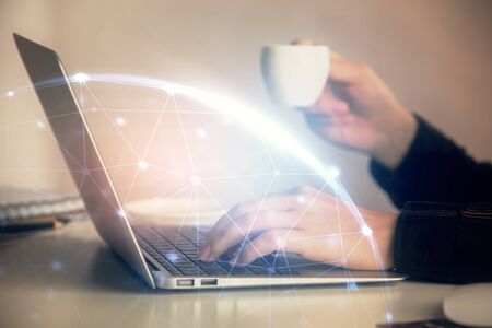 Double exposure of woman hands typing on computer and social network theme hologram drawing. People...