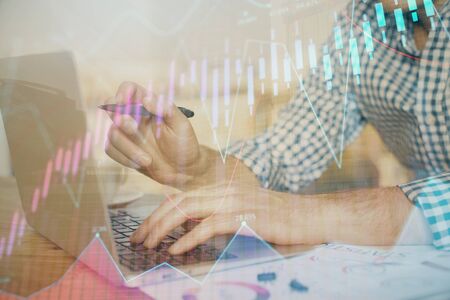 Multi exposure of forex graph with man working on computer on background. Concept of market...