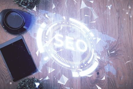 Double exposure of SEO hologram drawing over desktop. Top view. Search optimization concept.の写真素材