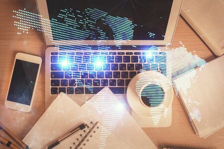 Social network hologram drawings over computer on the desktop background. Top view. Double exposure.の写真素材