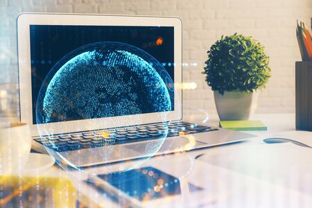Double exposure of desktop with computer and world map hologram. International data network concept.の写真素材