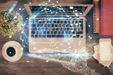 Social network hologram drawings over computer on the desktop background. Top view. Double exposure.の写真素材
