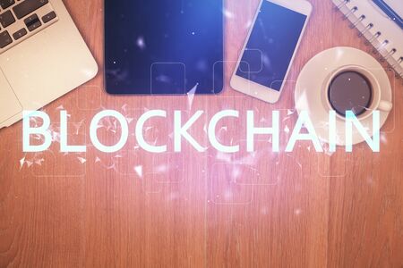 Double exposure of blockchain theme hologram over table with phone. Top view. Crypto technology concept.の写真素材