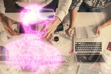 Double exposure of man and woman working together and man in virtual glasses hologram drawing. Computer background. Top View. VR, AR concept.の写真素材