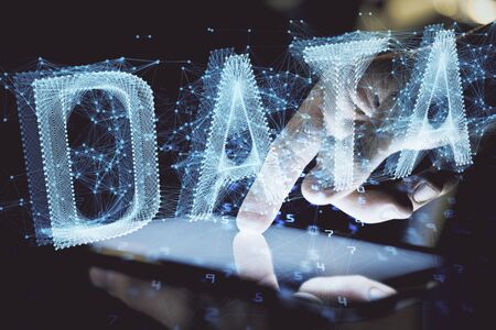 Double exposure of mans hand holding and using a digital device and data theme hologram drawing. Technology concept.の写真素材