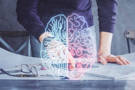 Double exposure of mans hand holding and using a digital device and brain hologram drawing. Data...