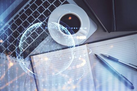 Double exposure of map hologram drawing over study table background with computer. Concept of international network. Top view.の写真素材