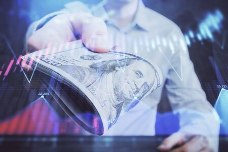 Multi exposure of financial graph drawing hologram and USA dollars bills and man hands. Analysis concept.の写真素材
