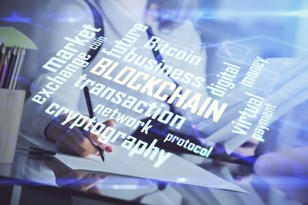 Cryptocurrency hologram over woman's hands writing background. Concept of blockchain. Double exposureの写真素材