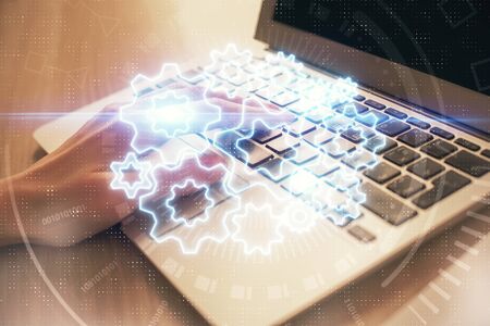 Double exposure of woman hands typing on computer and business theme hologram drawing. Success concept.の写真素材