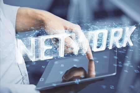 Double exposure of mans hand holding and using a digital device and data theme hologram drawing. Technology concept.の写真素材