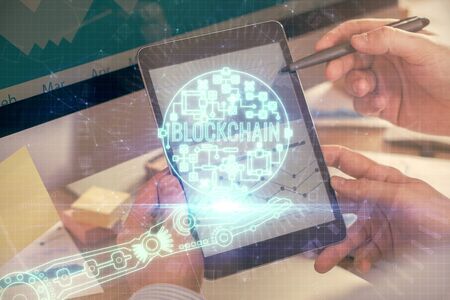 Double exposure of mans hands holding and using a phone and crypto currency blockchain theme...