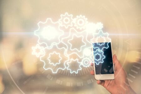 Double exposure of business theme sketch hologram and woman holding and using a mobile device.の写真素材