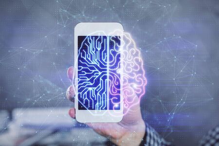 Double exposure of mans hand holding and using a digital device and brain hologram drawing. Data...