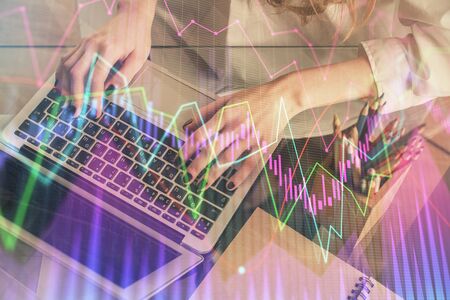 Double exposure of woman hands typing on computer and forex chart hologram drawing. Stock market...