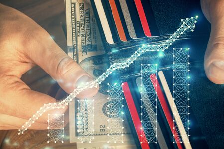 Multi exposure of forex graph drawing hologram and USA dollars bills and man hands. Technical...