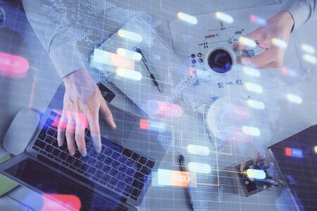 Double exposure of mans hands typing over computer keyboard and data theme hologram drawing. Top view. Technology concept.の写真素材