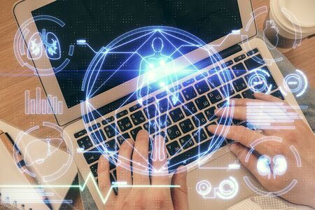 Double exposure of mans hands typing over computer keyboard and science theme hologram drawing. Top...