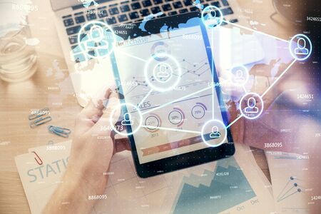 Double exposure of mans hands holding and using a phone and social network theme drawing.