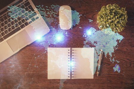 Social network hologram drawings over computer on the desktop background. Top view. Double exposure.の写真素材