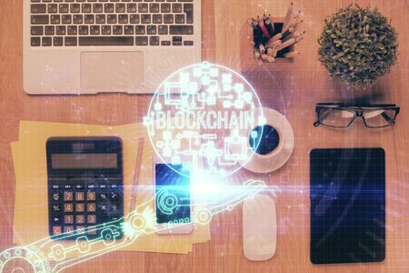 Double exposure of blockchain theme hologram over table with phone. Top view. Crypto technology concept.の写真素材