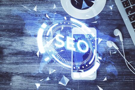 Double exposure of SEO hologram drawing over desktop. Top view. Search optimization concept.の写真素材