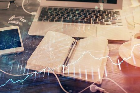 Multi exposure of financial graph drawings and desk with open notebook background. Concept of forexの写真素材