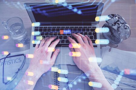 Double exposure of mans hands typing over computer keyboard and data theme hologram drawing. Top view. Technology concept.の写真素材