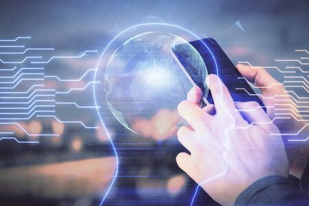 Double exposure of mans hand holding and using a digital device and brain hologram drawing. Data...