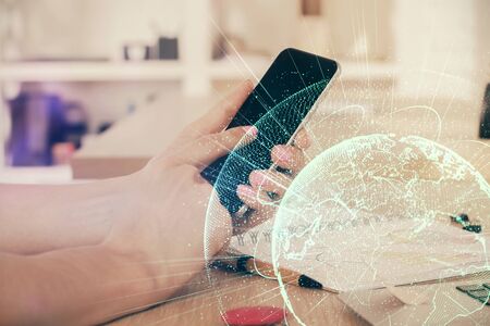 Double exposure of mans hands holding and using a phone and social network theme drawing.