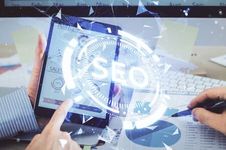 Multi exposure of mans hands holding and using a digital device and seo drawing. search optimization concept.の写真素材