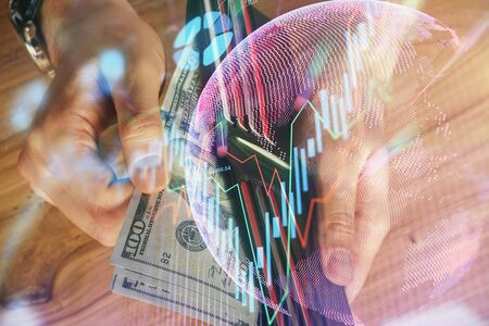 Multi exposure of forex graph drawing hologram and USA dollars bills and man hands. Technical...