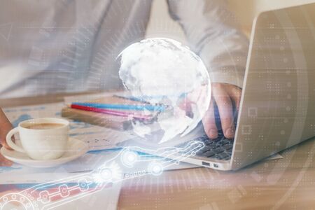 Double exposure of world map hologram with man working on computer on background. Concept of worldwideweb.の写真素材