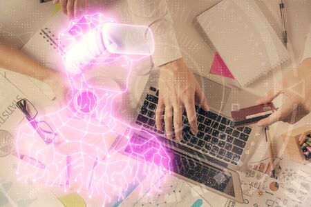 Double exposure of mans hands typing over computer keyboard and virtual reality hologram drawing. Top view. Technology concept. Future.の写真素材