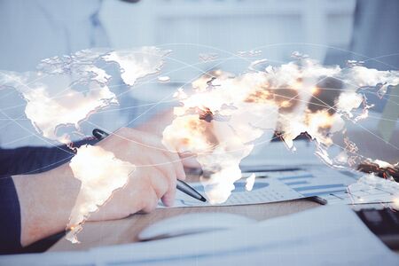 Double exposure of hands and notepad with business icons. Concept of international business.の写真素材