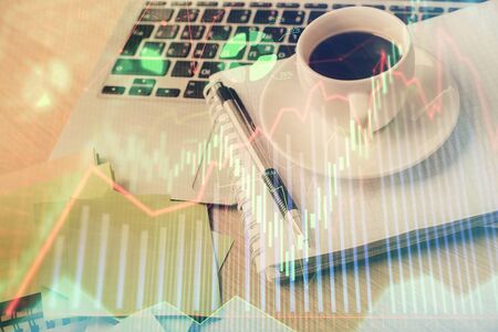 Double exposure of forex chart drawing and desktop with coffee and items on table background. Concept of financial market tradingの写真素材