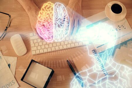 Double exposure of mans hands typing over computer keyboard and virtual reality hologram drawing. Top view. Technology concept. Future.の写真素材