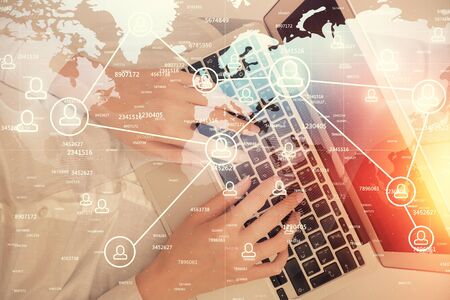Double exposure of woman hands working on computer and social network theme hologram drawing. Top...