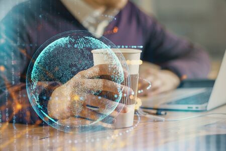 Double exposure of world map hologram with man working on computer on background. Concept of worldwideweb.の写真素材