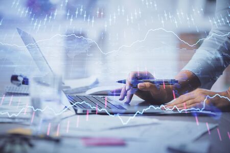 Double exposure of woman hands typing on computer and forex chart hologram drawing. Stock market...