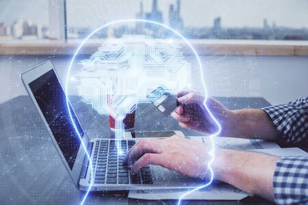 Double exposure of man hands typing on computer with credit card and brain theme drawing. E-commerce...